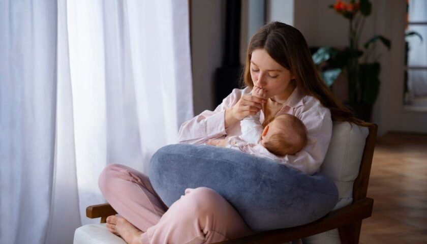 Mother comfortably breastfeeding baby with proper positioning support